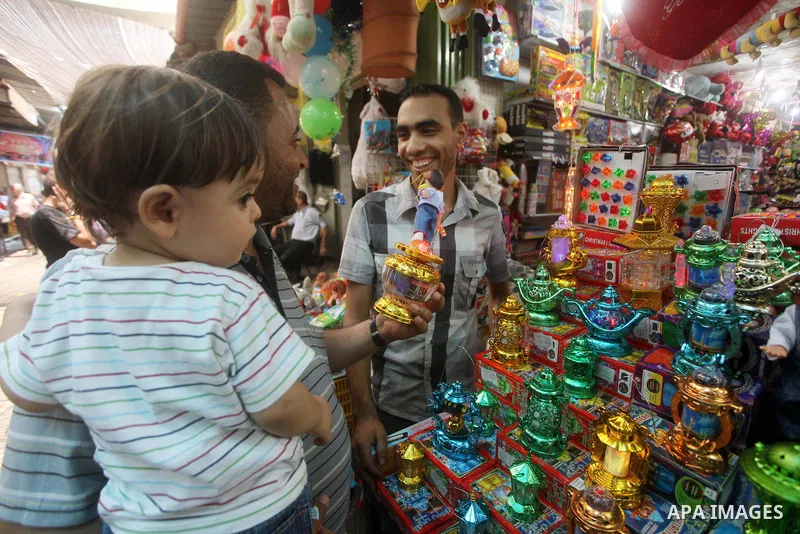 Palestinians Inspect goods as the vendor displays it in preparation for the holy month of Ramadan in the Gaza city on July 17, 2012 . Islam's holy month of Ramadan will begin in few days depending on the sighting of the...