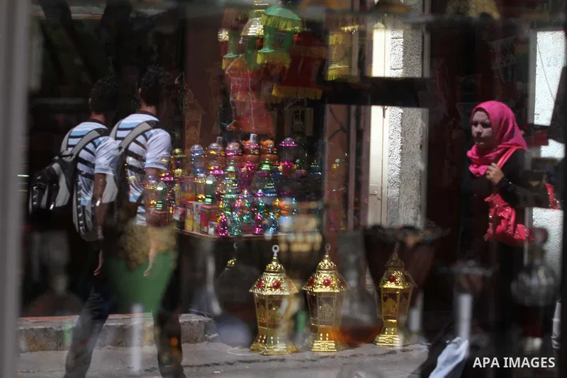 Palestinians walk in front of the shop as the vendor displays goods in preparation for the holy month of Ramadan in the Gaza city on July 17, 2012 . Islam's holy month of Ramadan will begin in few days depending on the s...