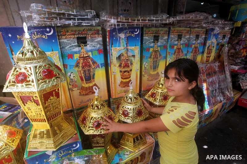 A Palestinian child Inspects toys as the vendor displays goods in preparation for the holy month of Ramadan in the Gaza city on July 17, 2012 . Islam's holy month of Ramadan will begin in few days depending on the sighti...
