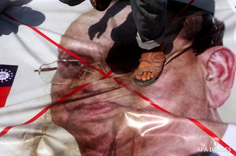 Palestinian supporters of the Popular Resistance Movement linked Hamas, burn a U.S. flag and hold a poster of Myanmar's President Thein Sein reading in Arabic "President of Burma despicable," during a demonstration calli...
