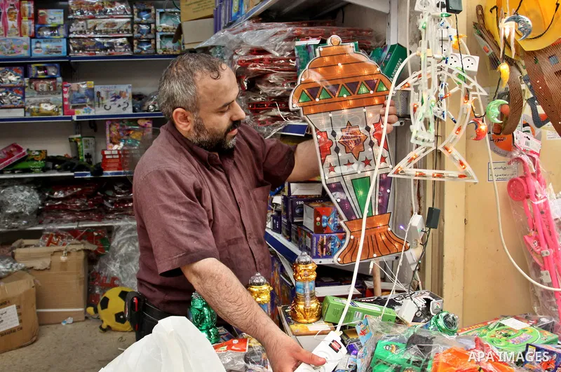 A Palestinian vendor decorates his shop with an electric crescent in preparation for the holy month of Ramadan in the West Bank city of Nablus, on July 18, 2012 . Islam's holy month of Ramadan will begin in few days depe...