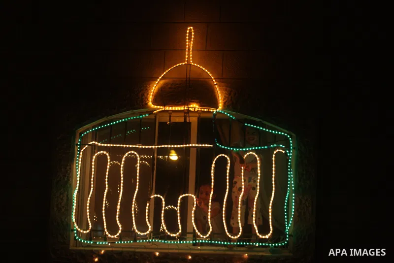 Palestinians hang up decorations before the Muslim holy month of Ramadan and write in Arabic, (Ramadan Karim) in their house in al-Bireh close to the West Bank city of Ramallah on July 18, 2012. The Muslim holy month of...