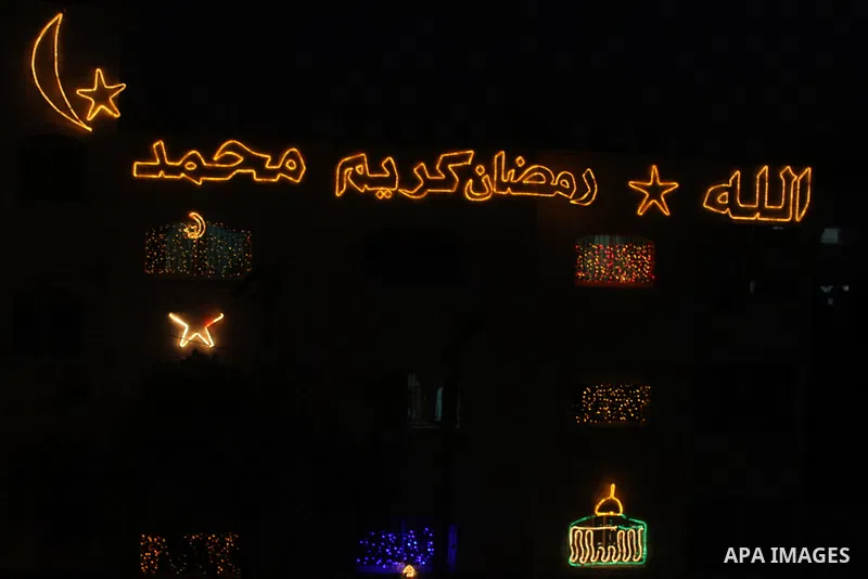 Palestinians hang up decorations before the Muslim holy month of Ramadan and write in Arabic, (Ramadan Karim) in their house in al-Bireh close to the West Bank city of Ramallah on July 18, 2012. The Muslim holy month of...