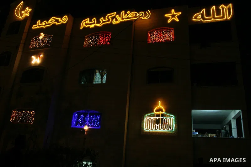 Palestinians hang up decorations before the Muslim holy month of Ramadan and write in Arabic, (Ramadan Karim) in their house in al-Bireh close to the West Bank city of Ramallah on July 18, 2012. The Muslim holy month of...