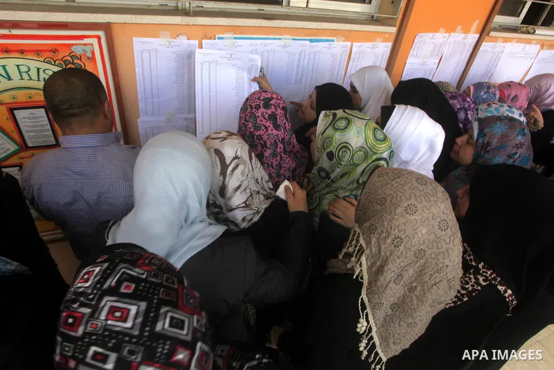 Palestinian secondary school students read a local newspaper to find their results in Gaza city on July 19, 2012. The Ministry of Education in Gaza Strip and the West Bank announced the results together. Photo by Ashraf...