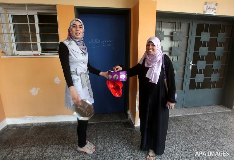 Palestinian secondary school student distributes sweets after find their results in Gaza city on July 19, 2012. The Ministry of Education in Gaza Strip and the West Bank announced the results together. Photo by Ashraf Am...