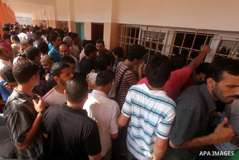 Palestinian secondary school students read a local newspaper to find their results in Gaza city on July 19, 2012. The Ministry of Education in Gaza Strip and the West Bank announced the results together. Photo by Ashraf...