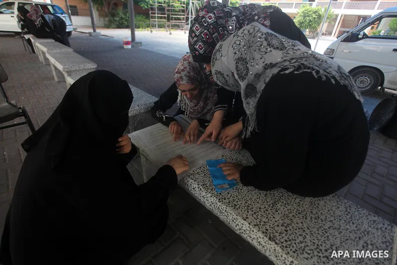 Palestinian secondary school students read a local newspaper to find their results in Gaza city on July 19, 2012. The Ministry of Education in Gaza Strip and the West Bank announced the results together. Photo by Ashraf...