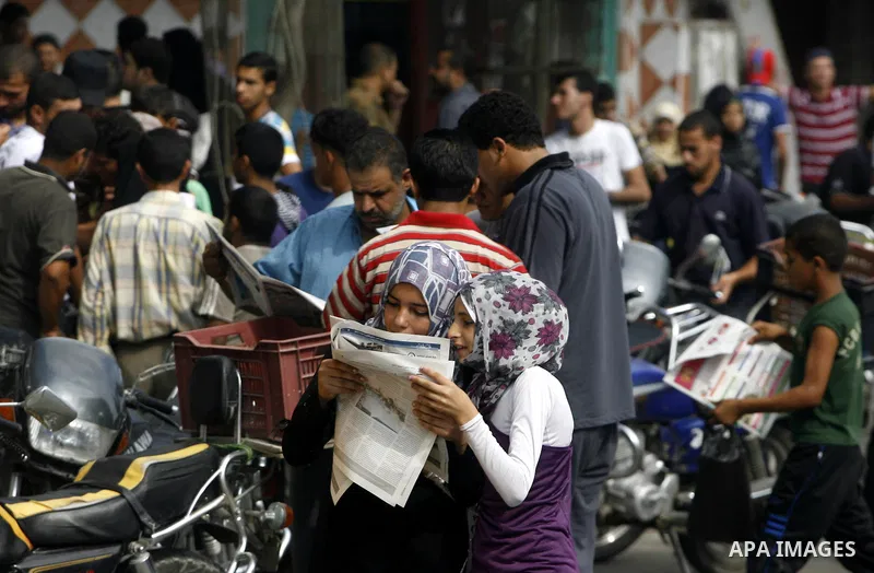 Palestinian secondary school students read a local newspaper to find their results in Rafah in the southern Gaza Strip on July 19, 2012. The Ministry of Education in Gaza Strip and the West Bank announced the results tog...