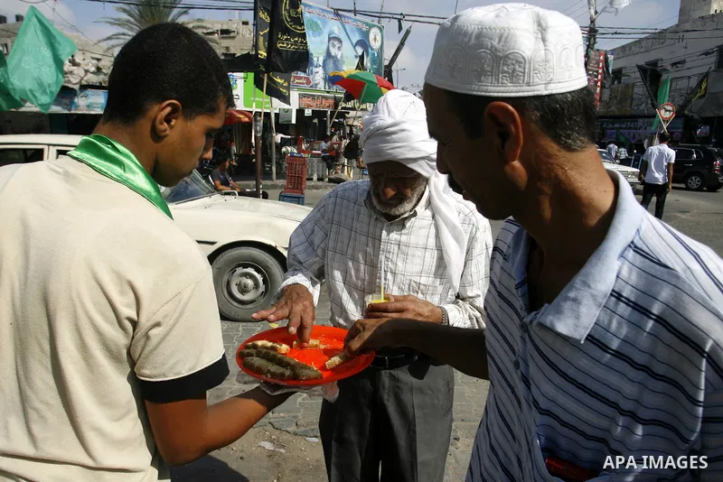 Palestinian secondary school students read a local newspaper to find their results in Rafah in the southern Gaza Strip on July 19, 2012. The Ministry of Education in Gaza Strip and the West Bank announced the results tog...