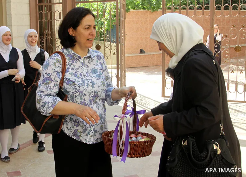 A Palestinian woman gives candy after heard the results of final exams of her high school daughter known as "Tawjihi" in the West Bank city of Nablus, on July 19, 2012. The Ministry of Education in Gaza Strip announced t...