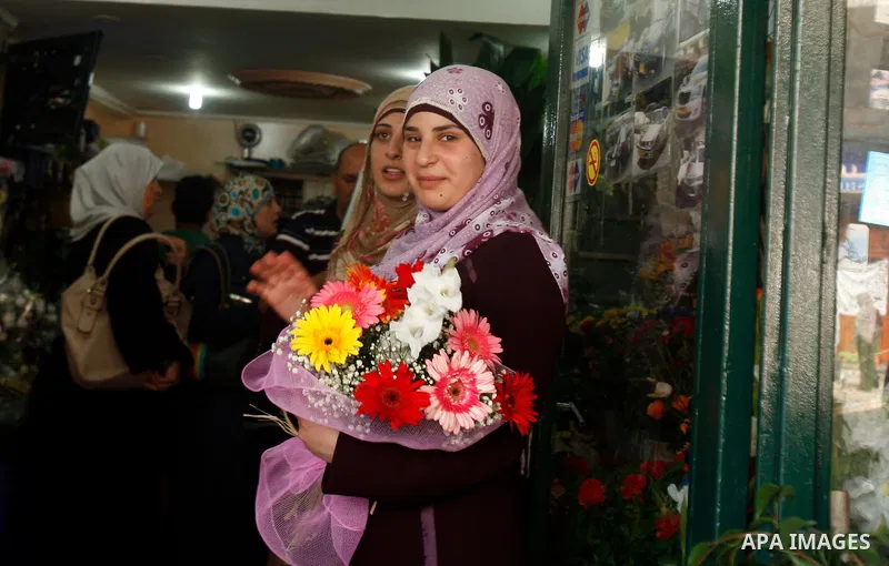 Palestinian high school students buy flowers after heard their results of final exams known as "Tawjihi" in Jerusalem, on July 19, 2012. The Ministry of Education in Gaza Strip announced the final results coincide with t...