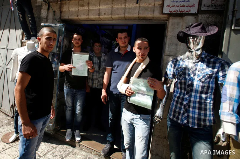 Palestinian high school students show the results of their final exams known as "Tawjihi" in Jerusalem, on July 19, 2012. The Ministry of Education in Gaza Strip announced the final results coincide with the West Bank. P...