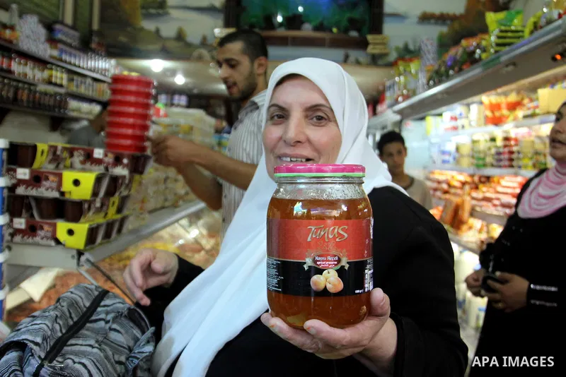 A Palestinian woman shows foodstuff in a shop in preparation for the holy month of Ramadan in the West Bank city of Nablus, on July 19, 2012 . Islam's holy month of Ramadan will begin in two days depending on the sightin...