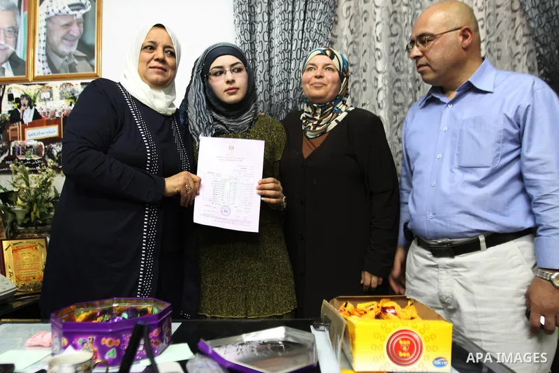 A Palestinian high school student and the first on provinces of Palestine, Sara Shwiki celebrates with her family after heard the results of her final exams known as ''Tawjihi'' in the West Bank city of Hebron, on July 1...