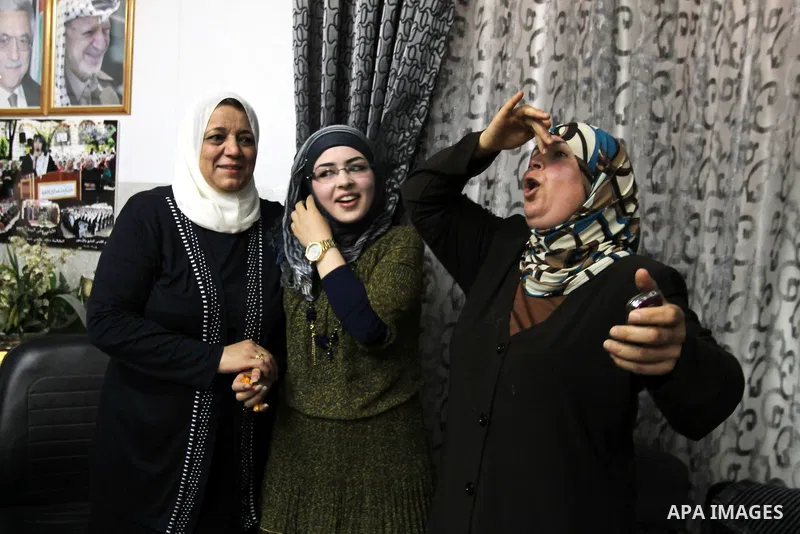 A Palestinian high school student and the first on provinces of Palestine, Sara Shwiki celebrates with her family after heard the results of her final exams known as ''Tawjihi'' in the West Bank city of Hebron, on July 1...