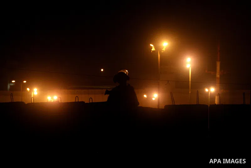 An Israeli border police officer checks documents of Palestinians who wait to cross the Qalandia checkpoint on the outskirts of the West Bank city of Ramallah on July 20, 2012 as they head to the Al-Aqsa mosque compound...
