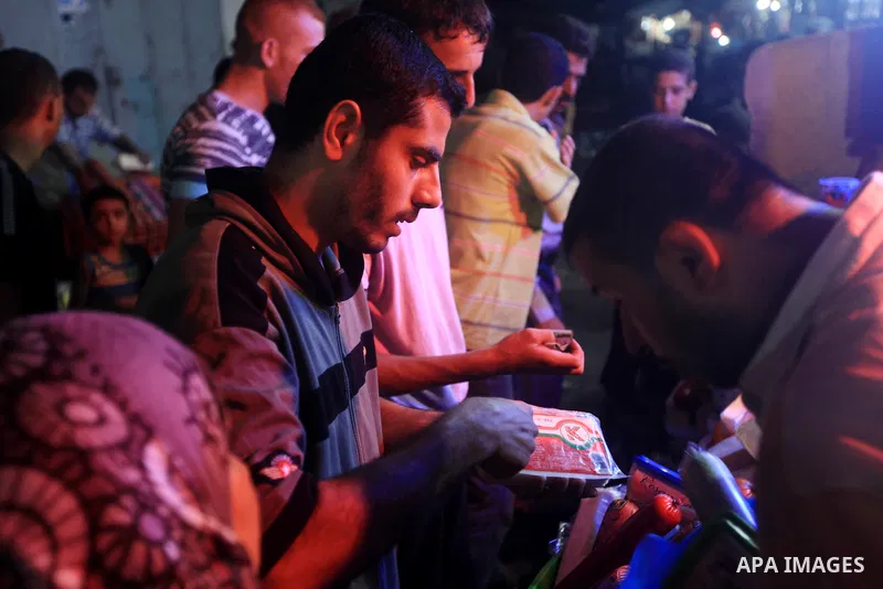 Palestinians Inspect goods as the vendor displays it in preparation for the holy month of Ramadan in the Gaza city on July 19, 2012 .Ramadan is the ninth month of the Islamic calender, a month of fasting, in which partic...