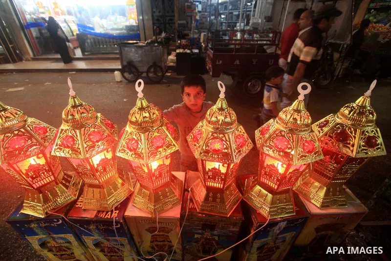 A Palestinian child Inspects toys and electric lights as the vendor displays goods in preparation for the holy month of Ramadan in the Gaza city on July 19, 2012. Ramadan is the ninth month of the Islamic calender, a mon...