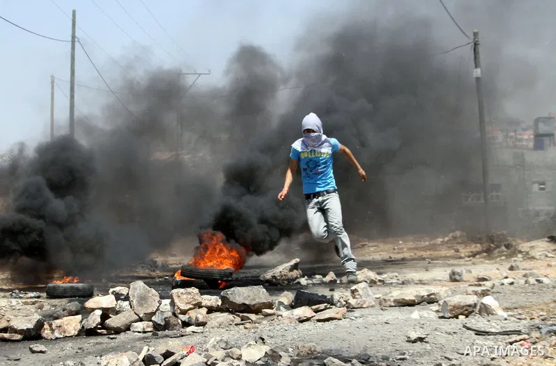 A Palestinian protestor throws stones at Israeli troops during clashes as they protest against the Jewish settlement of Kdumim, near Nablus, West Bank, 20 July 2012. According to medical sources 16 Palestinians were inju...