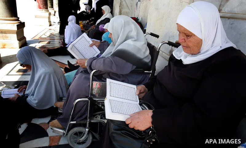 Palestinian read the Koran outside the Dome of the Rock on the compound known to Muslims as Noble Sanctuary and to Jews as Temple Mount in Jerusalem's Old City on the first Friday of the holy month of Ramadan July 20, 20...