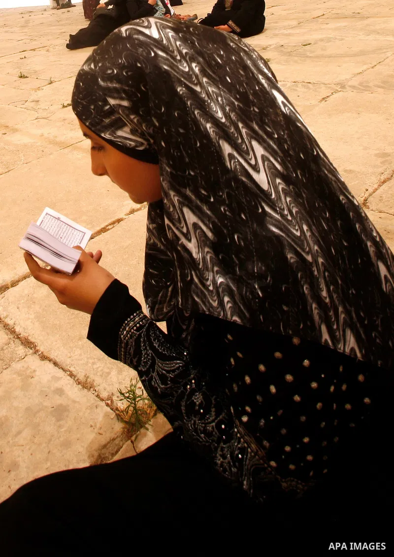 Palestinian read the Koran outside the Dome of the Rock on the compound known to Muslims as Noble Sanctuary and to Jews as Temple Mount in Jerusalem's Old City on the first Friday of the holy month of Ramadan July 20, 20...