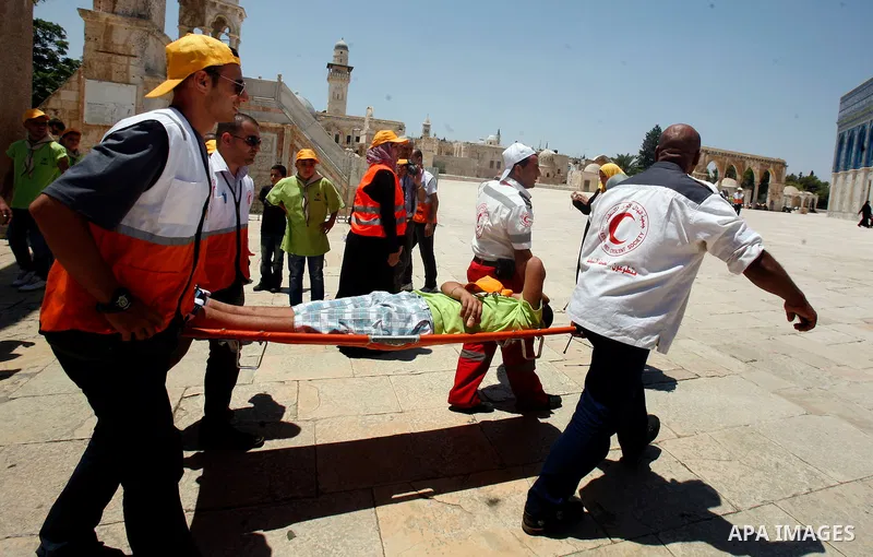 Palestinian medics carry an injured man during friday prayer in al-Aqsa mosque in Jerusalem's Old City on the first Friday of the holy month of Ramadan July 20, 2012. Israeli police said that Palestinian males over the a...