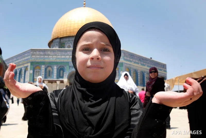 A Palestinian girl prays outside the Dome of the Rock on the compound known to Muslims as Noble Sanctuary and to Jews as Temple Mount in Jerusalem's Old City on the first Friday of the holy month of Ramadan July 20, 2012...