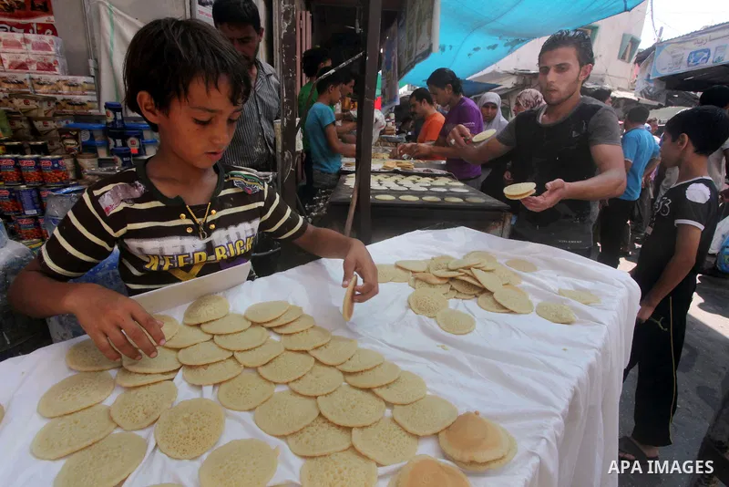 A Palestinian vendor prepares a traditional pancake known as "Qatayef" on the second day of the holy month of Ramadan, at a shop in Gaza City, on 21 July 2012. Muslims around the world abstain from eating, drinking and c...