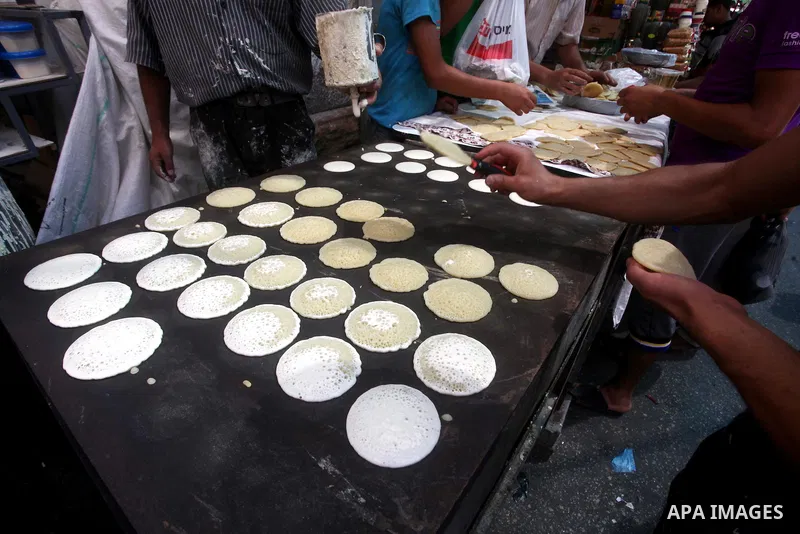 A Palestinian vendor prepares a traditional pancake known as "Qatayef" on the second day of the holy month of Ramadan, at a shop in Gaza City, on 21 July 2012. Muslims around the world abstain from eating, drinking and c...