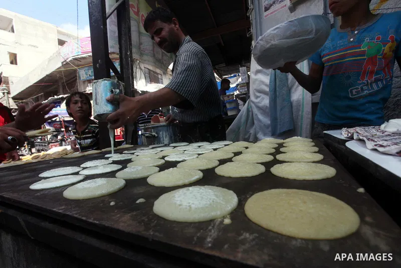 A Palestinian vendor prepares a traditional pancake known as "Qatayef" on the second day of the holy month of Ramadan, at a shop in Gaza City, on 21 July 2012. Muslims around the world abstain from eating, drinking and c...