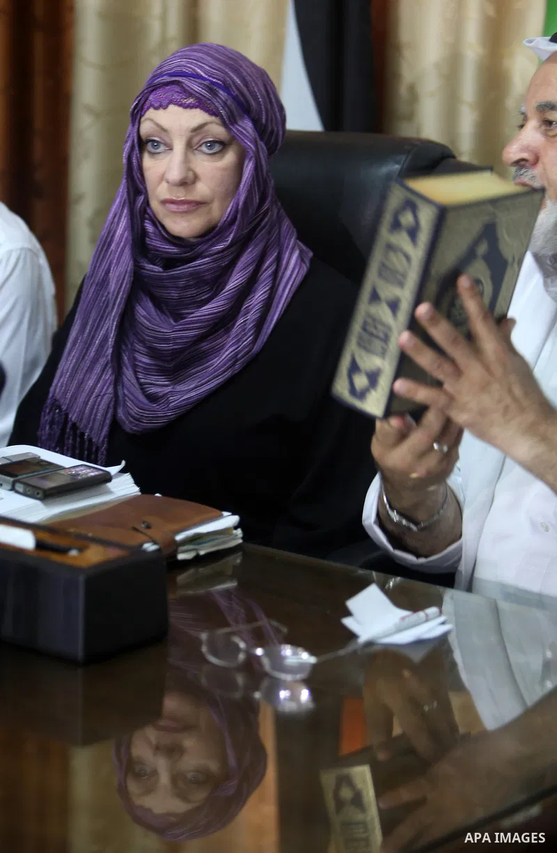 Palestinian Sheik Salem Salama holds a copy of the Koran before presenting it to Anne Kennedy, 49, at the headquarters of the Palestinian Muslim Scholars association in Gaza City July 21, 2012. British citizen Kennedy, w...