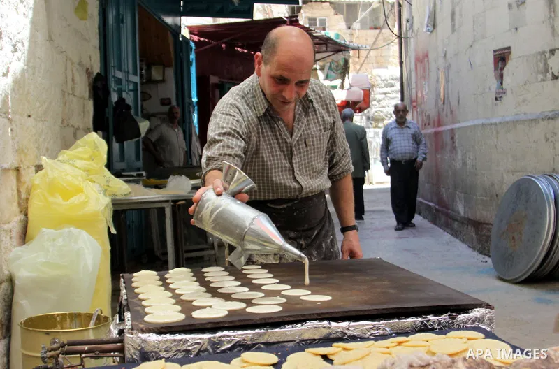 A Palestinian sweet-maker prepares traditional pancake known as "Qatayef" consumed during Ramadan in the West Bank city of Nablus, on July 22, 2012. Muslims around the world abstain from eating, drinking and conducting s...