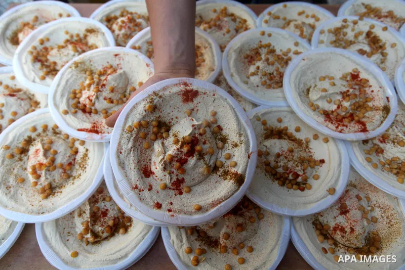 A Palestinian displays dishes of traditional chickpeas known as "Hummus" during Ramadan in Gaza city, on July 23, 2012. Muslims around the world abstain from eating, drinking and conducting sexual relations from dawn til...