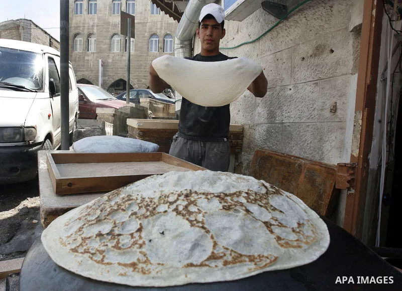 A Palestinian vendor bakes traditional bread during Ramadan in Jerusalem's old city, on July 23, 2012. Muslims around the world abstain from eating, drinking and conducting sexual relations from dawn till dusk during Ram...