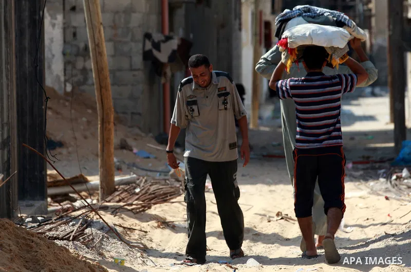 Palestinians carry loaves of bread baked in a traditional mud oven during Ramadan in Jabalya refugee camp, northen Gaza Strip on July 23, 2012. Muslims around the world abstain from eating, drinking and conducting sexual...