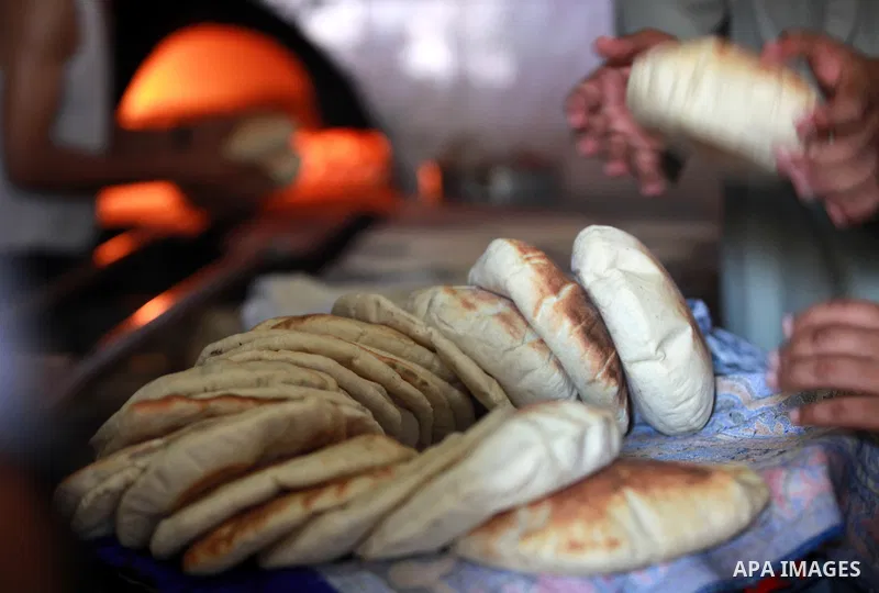 A Palestinian man bakes loaves of bread in his traditional mud oven during Ramadan in Jabalya refugee camp, northen Gaza Strip on July 23, 2012. Muslims around the world abstain from eating, drinking and conducting sexua...