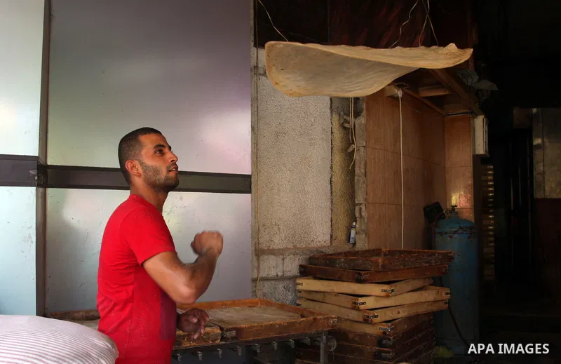 A Palestinian man bakes bread during the fasting month of Ramadan in the West Bank city of Ramallah, on July 23, 2012. Muslims around the world abstain from eating, drinking and conducting sexual relations from dawn till...
