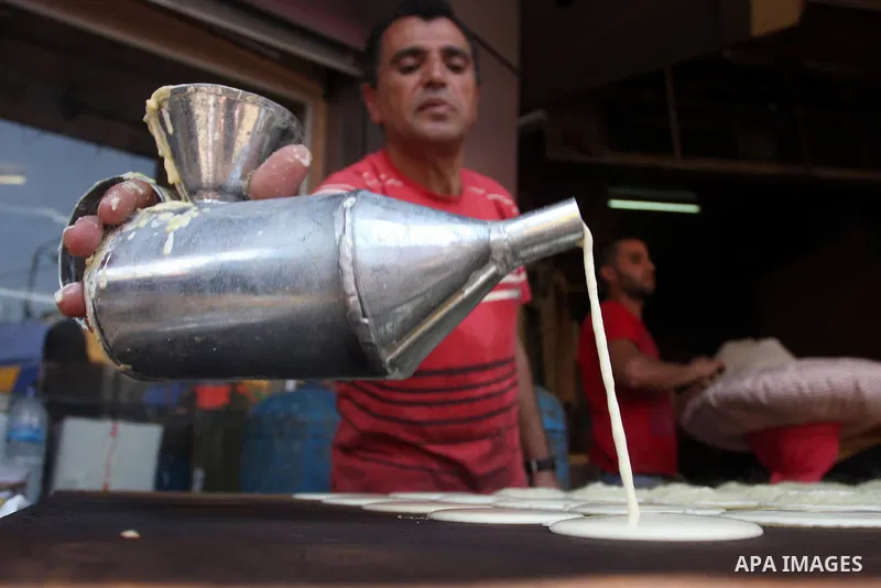A Palestinian man prepares traditional pancake known as ''Qatayef'' consumed during the fasting month of Ramadan in the West Bank city of Ramallah, on July 23, 2012. Muslims around the world abstain from eating, drinking...