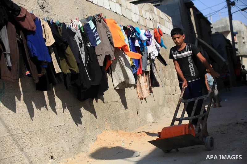A Palestinian child fills canisters with cooking gas in the Beach refugee camp in Gaza City before Breaking fast on the third day of the Holy month of Ramadan, in Gaza Strip, 24 July 2012. Muslims throughout the world ar...