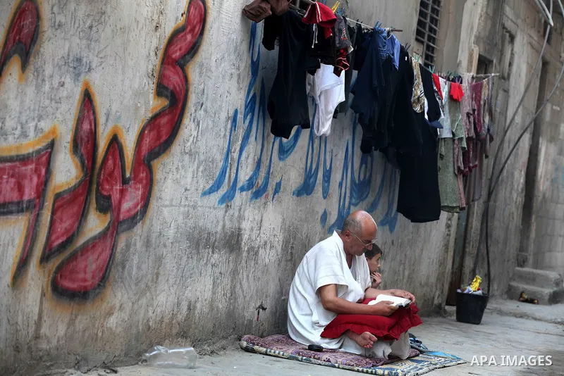 A Palestinian man reads the holy Qur'an in front of his home in the Beach refugee camp in Gaza City before Breaking fast on the third day of the Holy month of Ramadan, in Gaza Strip, 24 July 2012. Muslims throughout the...
