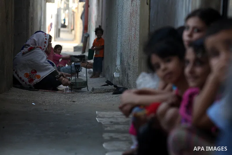 A Palestinian woman prepares food for the fast-breaking meal in front of her home in the Beach refugee camp in Gaza City before Breaking fast on the third day of the Holy month of Ramadan, in Gaza Strip, 24 July 2012. Mu...
