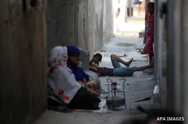 A Palestinian woman prepares food for the fast-breaking meal in front of her home in the Beach refugee camp in Gaza City before Breaking fast on the third day of the Holy month of Ramadan, in Gaza Strip, 24 July 2012. Mu...