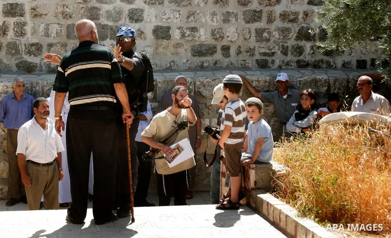 Jewish settlers walk past the Al-Aqsa mosque compound, Islam's third holiest site, during a visit under Israeli police protection in Jerusalem's old city on July 24, 2012. Photo by Mahfouz Abu Turk