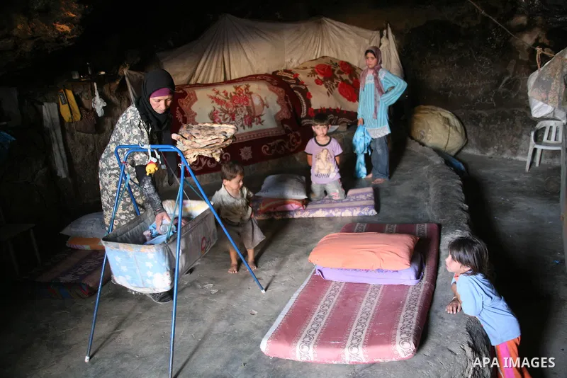 A Palestinian woman looks after her children in a cave, where they live, near the Palestinian village of Jimba, south of Yatta, near the West Bank town of Hebron on July 25, 2012. The Israeli Defence Minister, Ehud Barak...