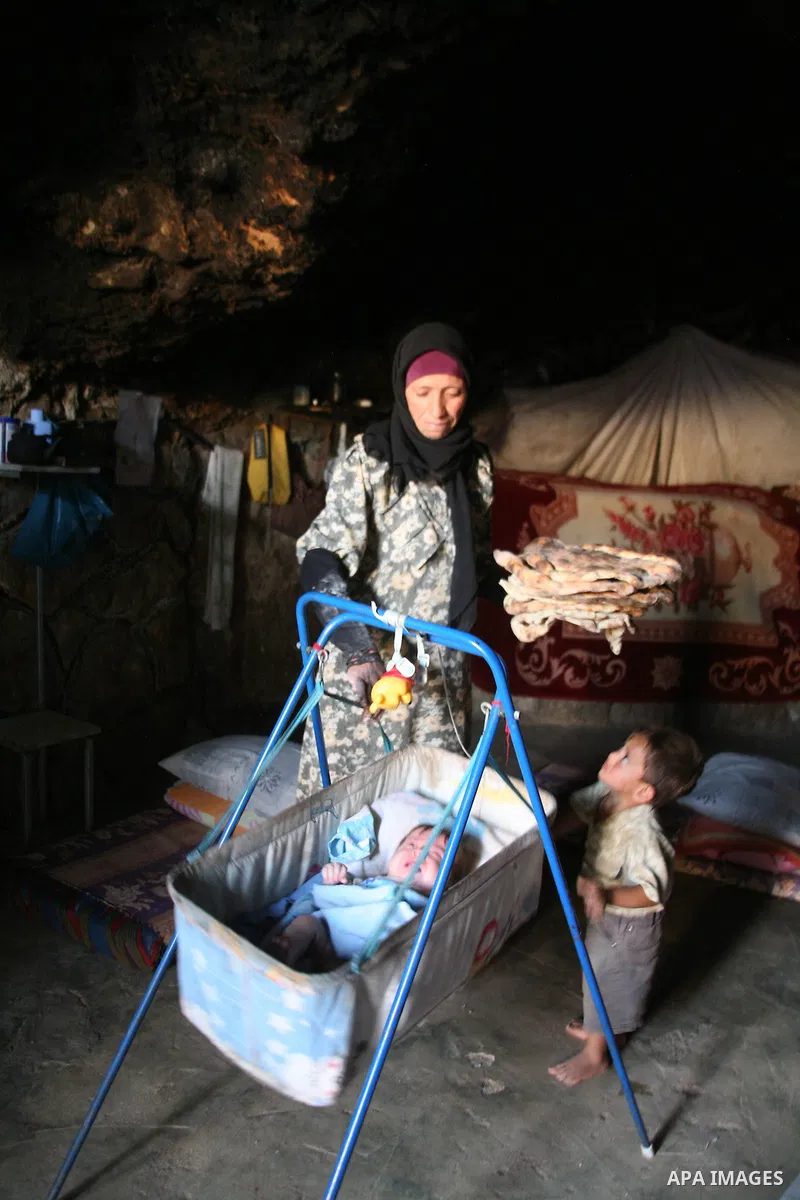 A Palestinian woman looks after her children in a cave, where they live, near the Palestinian village of Jimba, south of Yatta, near the West Bank town of Hebron on July 25, 2012. The Israeli Defence Minister, Ehud Barak...