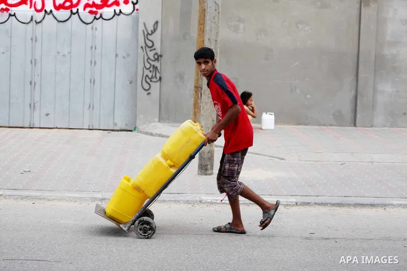 A Palestinian child carry potable water bottles filled on a cart near a water purification station, in Deir al-Balah central Gaza Strip, on July 11. 2012. Palestinians suffer from the severe lack of potable water during...
