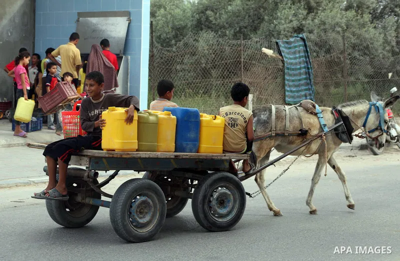 Palestinians fill their bottles a potable water at a water purification station, in Deir al-Balah central Gaza Strip, on July 26. 2012. Palestinians suffer from the severe lack of potable water during the holy fasting mo...