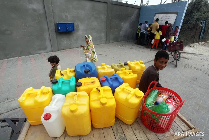 Palestinians fill their bottles a potable water at a water purification station, in Deir al-Balah central Gaza Strip, on July 26. 2012. Palestinians suffer from the severe lack of potable water during the holy fasting mo...