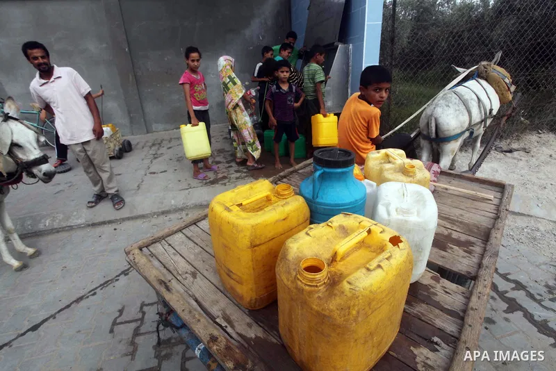 Palestinians fill their bottles a potable water at a water purification station, in Deir al-Balah central Gaza Strip, on July 26. 2012. Palestinians suffer from the severe lack of potable water during the holy fasting mo...
